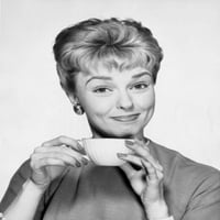 Portret srednje odrasle žene koja drži tisak plakata čaša za čaj